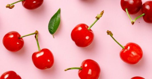 Cherries on a pink surface