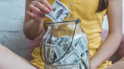 A woman saving money in a jar