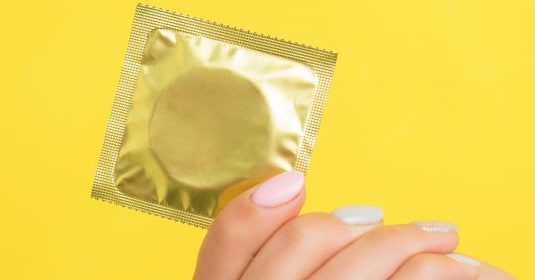 A woman holding a condom