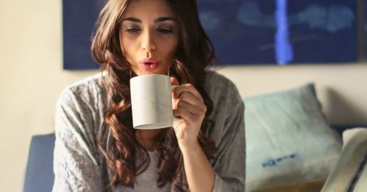 A woman drinking from a mug